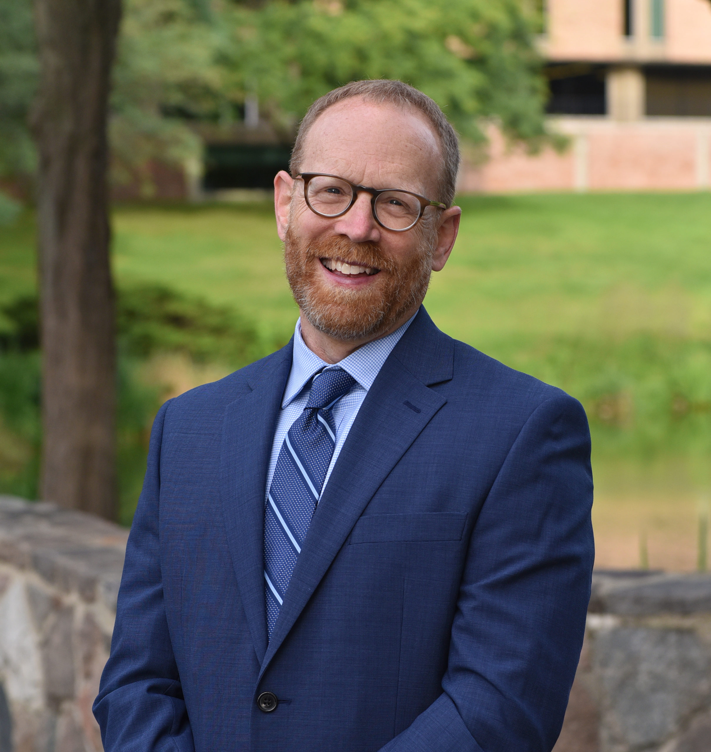 Dean David Gier in a blue suit outdoors