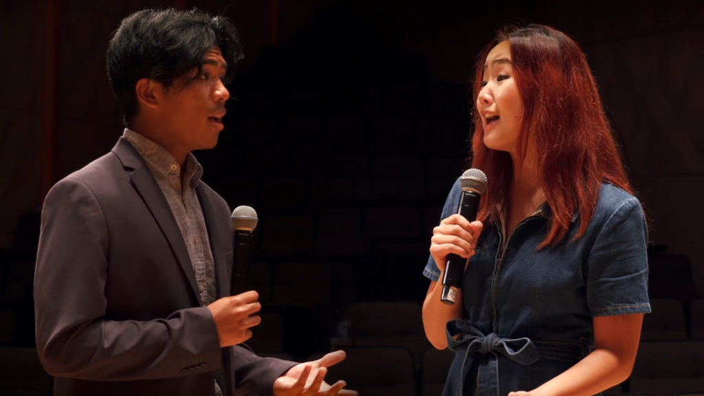 Christopher Tamayo and Helen Shen facing each other, holding microphones and singing.