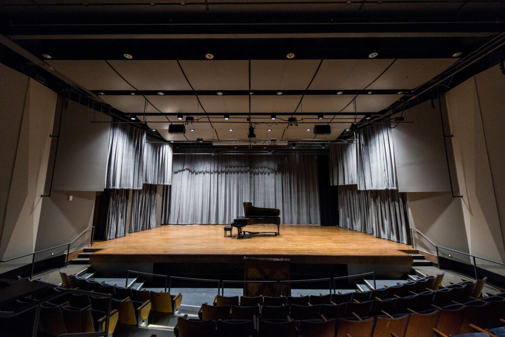 Piano on stage in an empty auditorium in the SMTD Moore Building