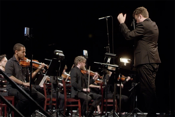 Professor Doug Perkins conducts 50 violinists at the Red Bull Music Festival