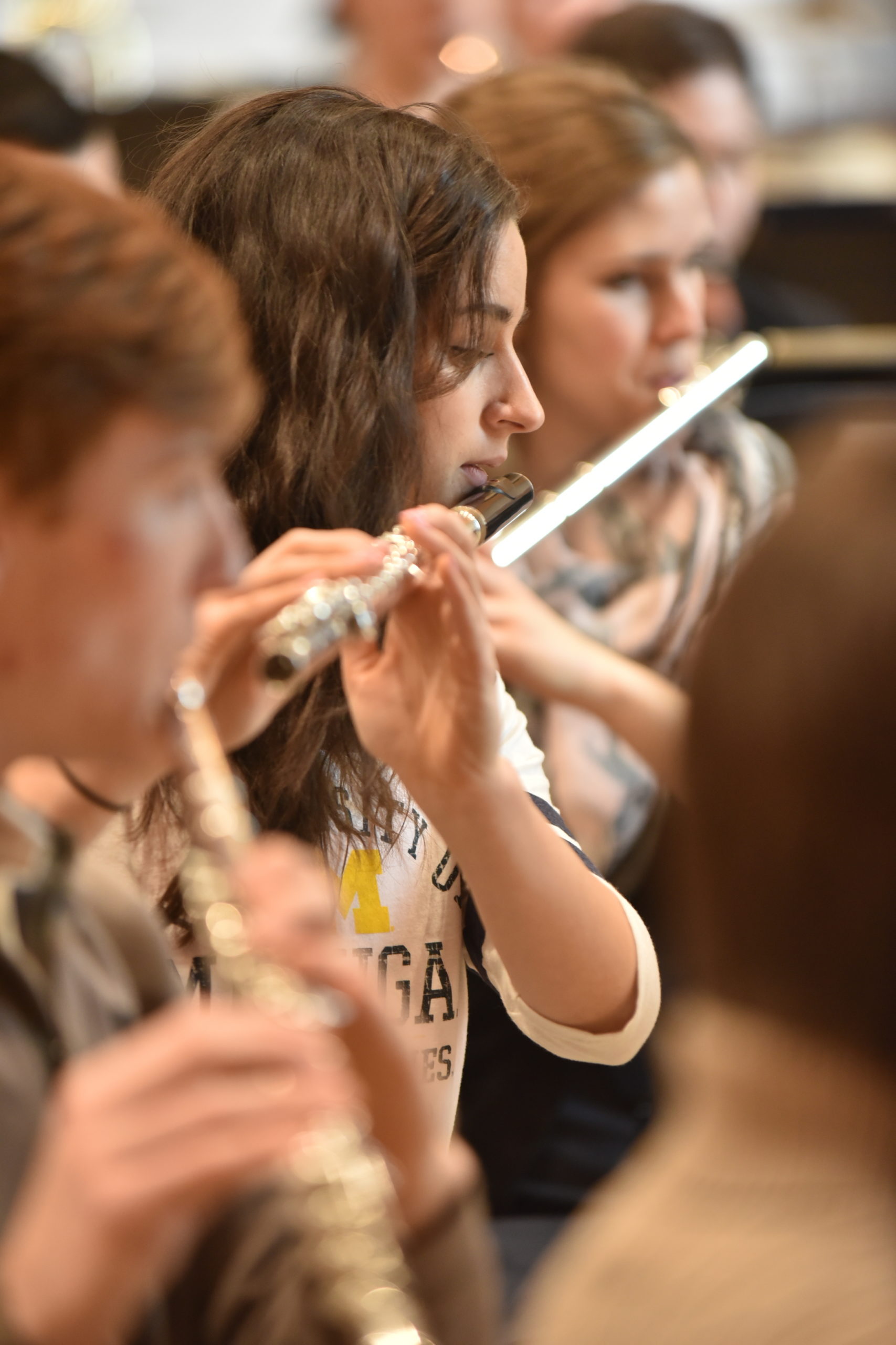 Three students playing the flutes