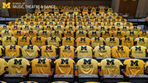 Zoom background - yellow SMTD shirts arrayed on seats in Britton Recital Hall