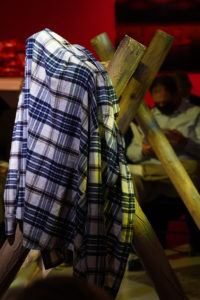 A plaid shirt hangs on an a-frame buck and rail fence.