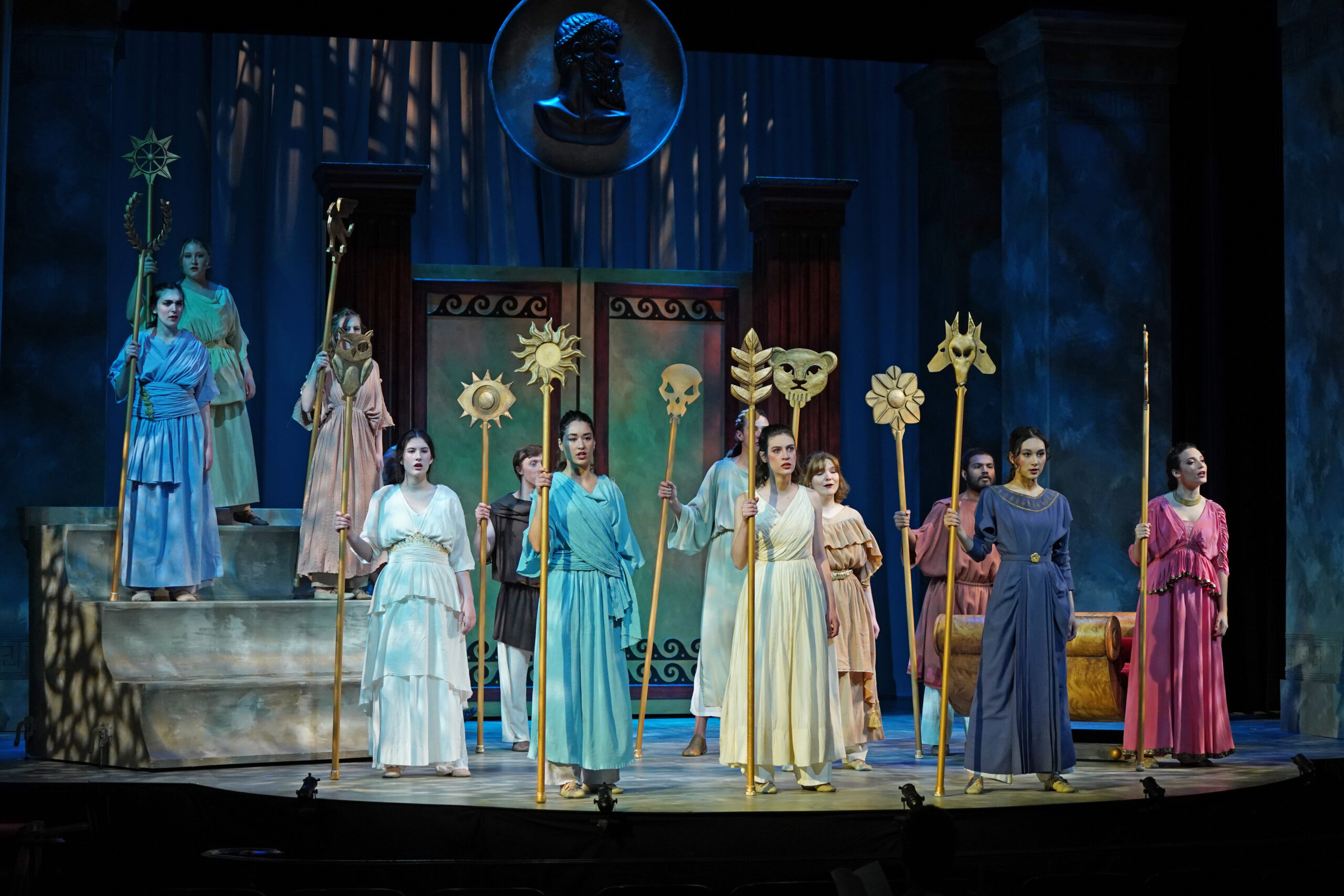 Several female actors on stage, dressed in period greek costumes. 