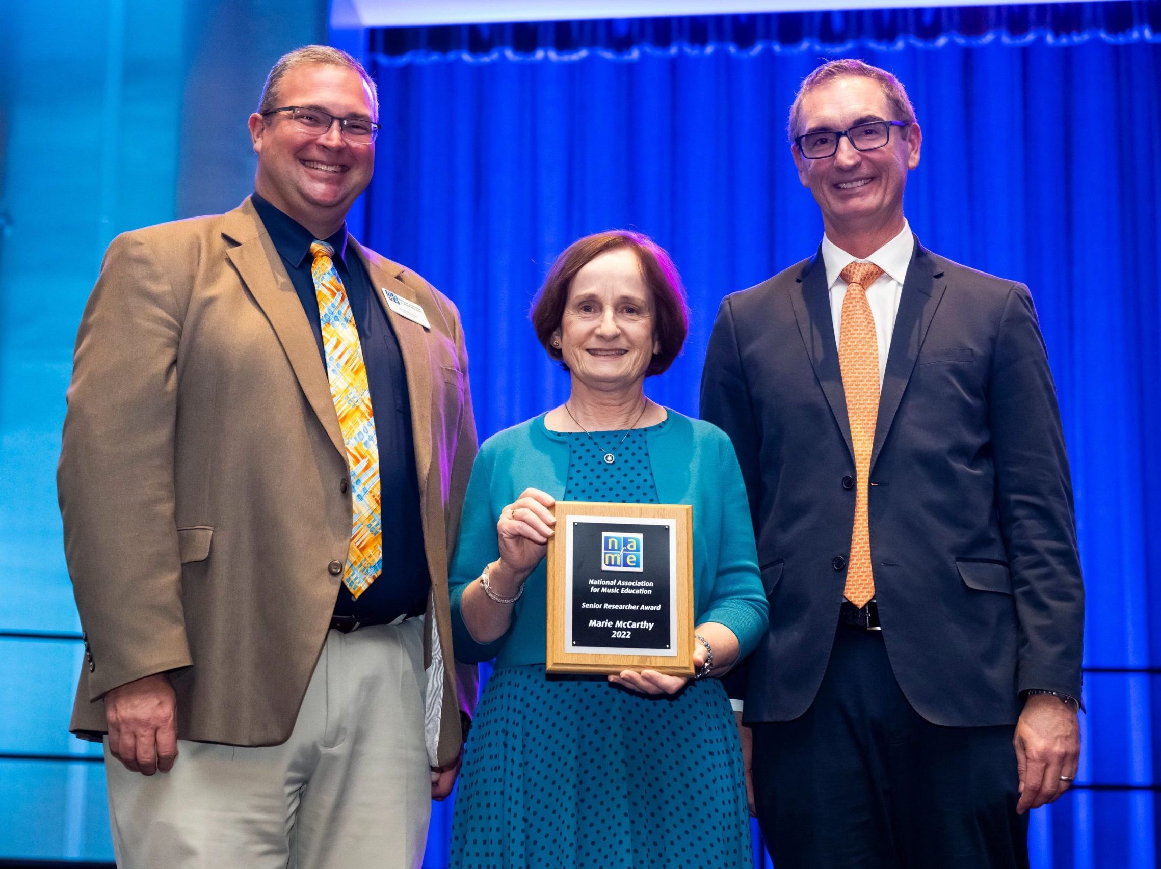NAfME President Scott R. Sheehan (left) and Carlos R. Abril, chair of the NAfME Society for Research in Music Education, present McCarthy with the Senior Researcher Award.