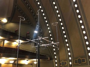 A framework of poles holds up eleven mounted microphones inside Hill Auditorium.