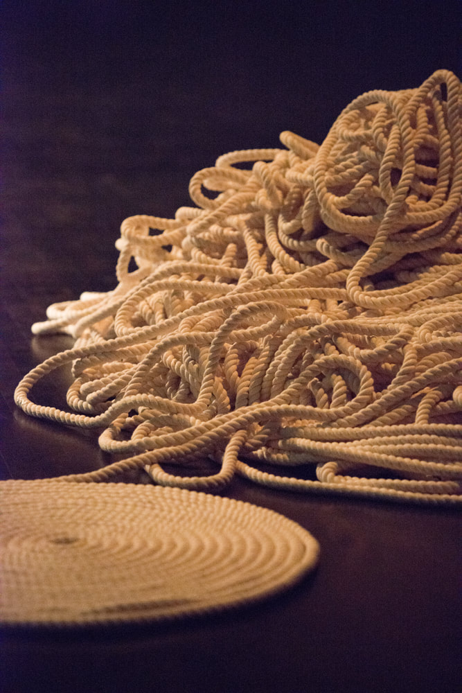 A neat spool of rope trails away into a tangled pile.