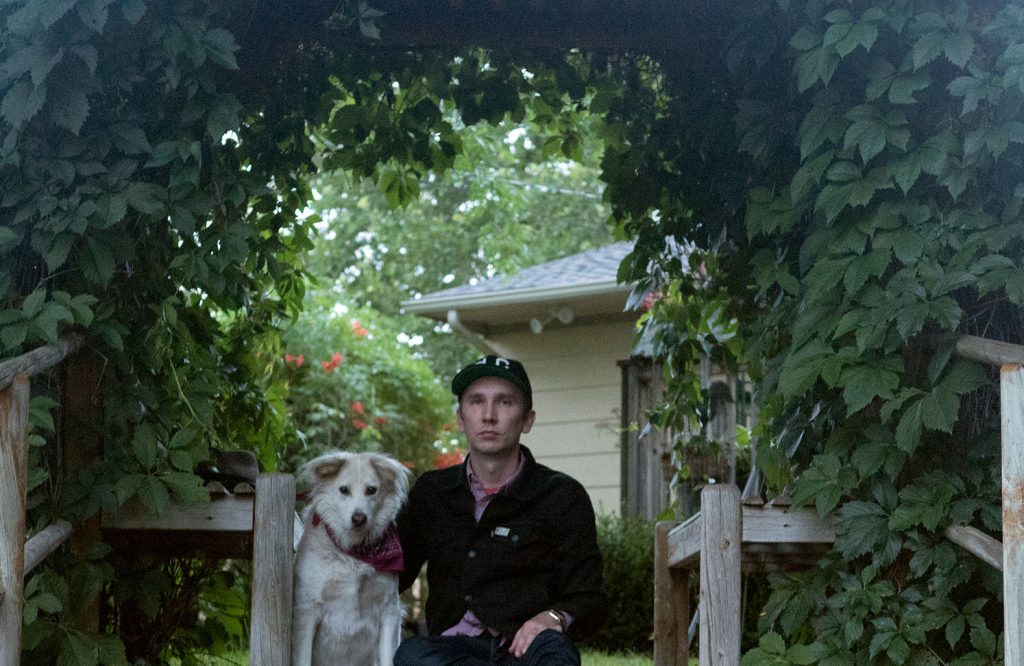 Gavin Ryan and his dog pictured on a verdant outdoor deck.