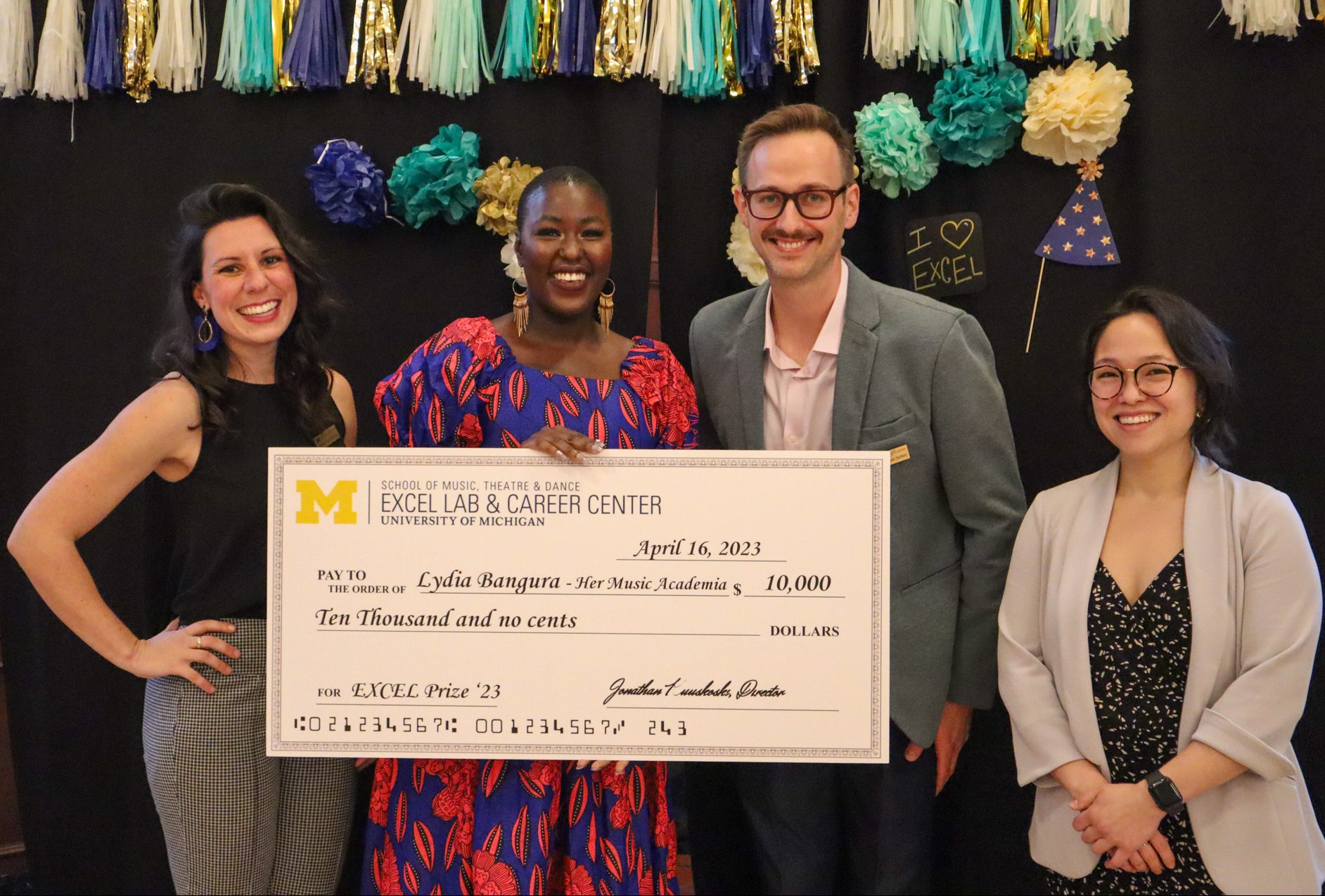 EXCEL Staff with 2023 EXCEL Prize winner, Lydia Bangura, who holds a large check