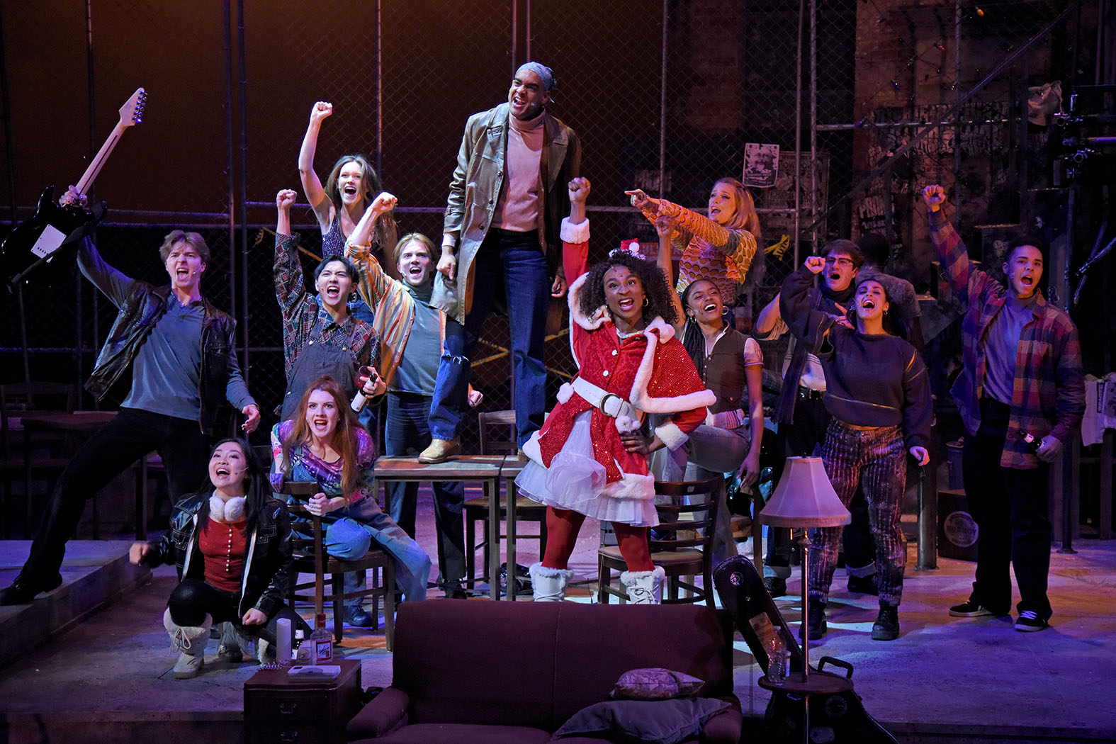In April 2023, the cast of RENT performs a song with fists raised.