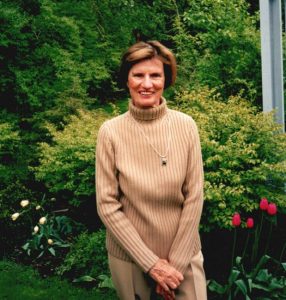 Janet Cassebaum poses with flowers and garden