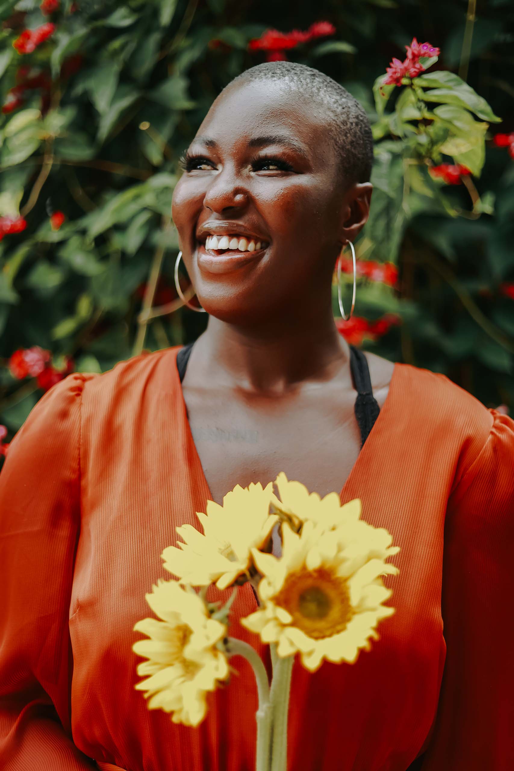 Lydia Bangura smiles and holds sunflowers