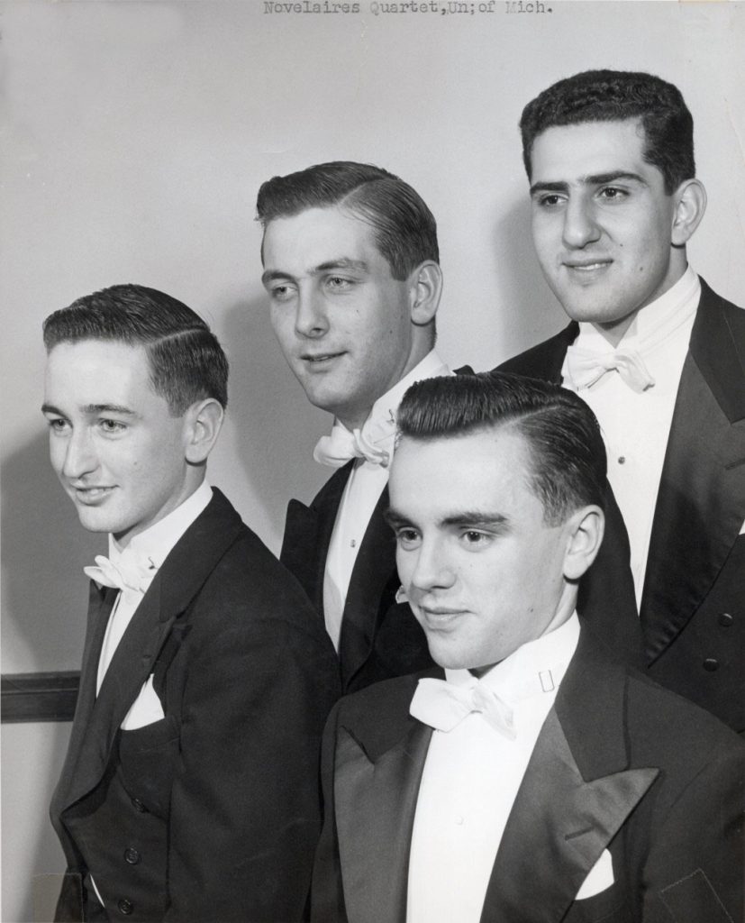 Greyscale, 1950s photo of 4 young men in tuxedos