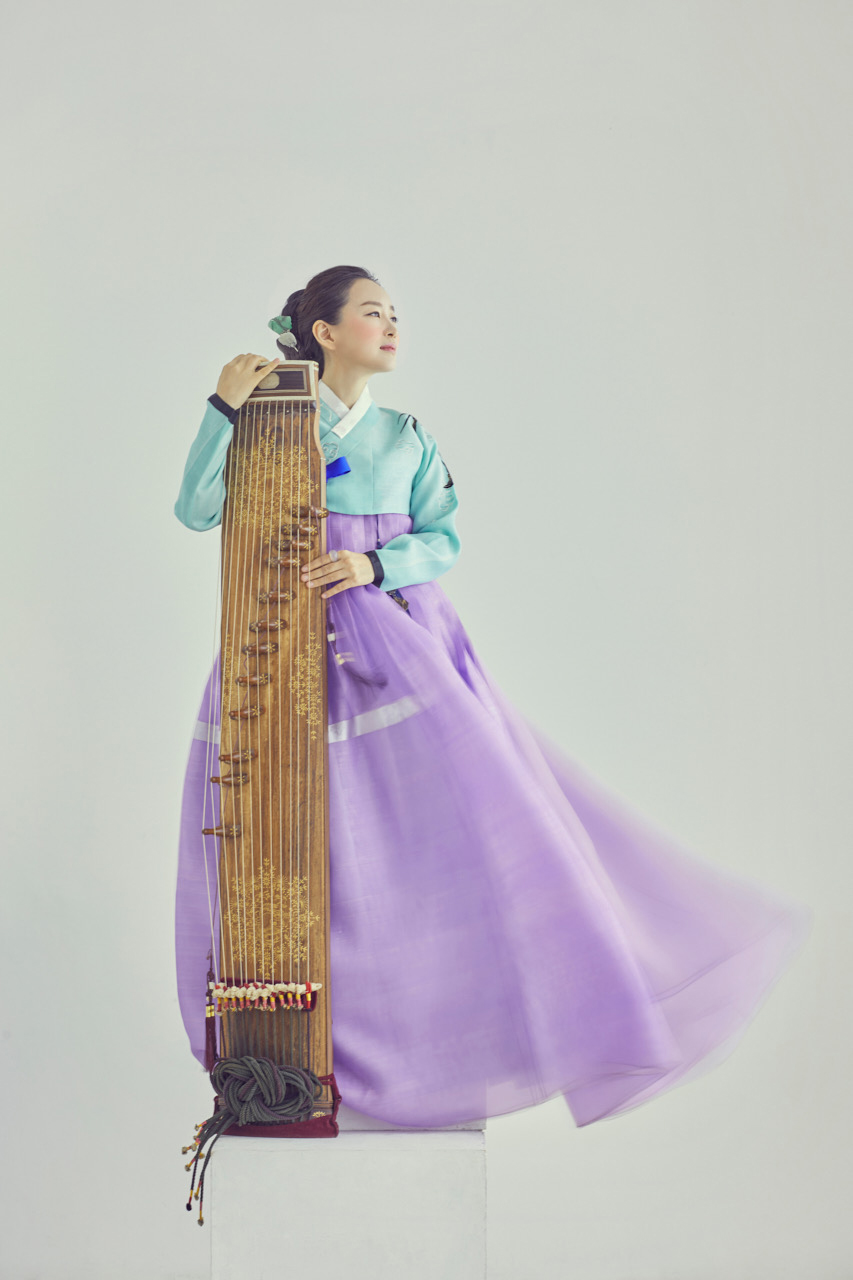 Seulgi Lee studio portrait with tall stringed instrument