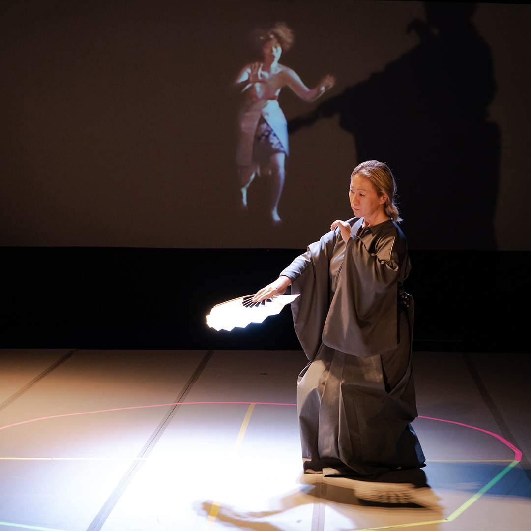 Yasuko Yokoshi performs with a fan and a projected image