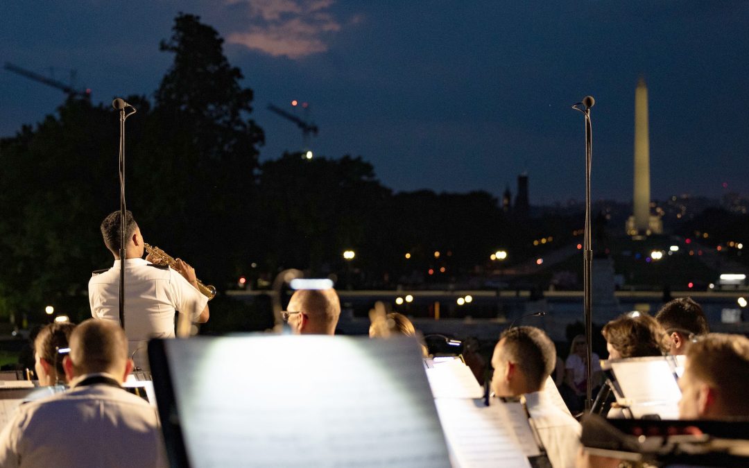 A view towards the Washington Monument with a military ensemble and trumpet soloist in the foreground