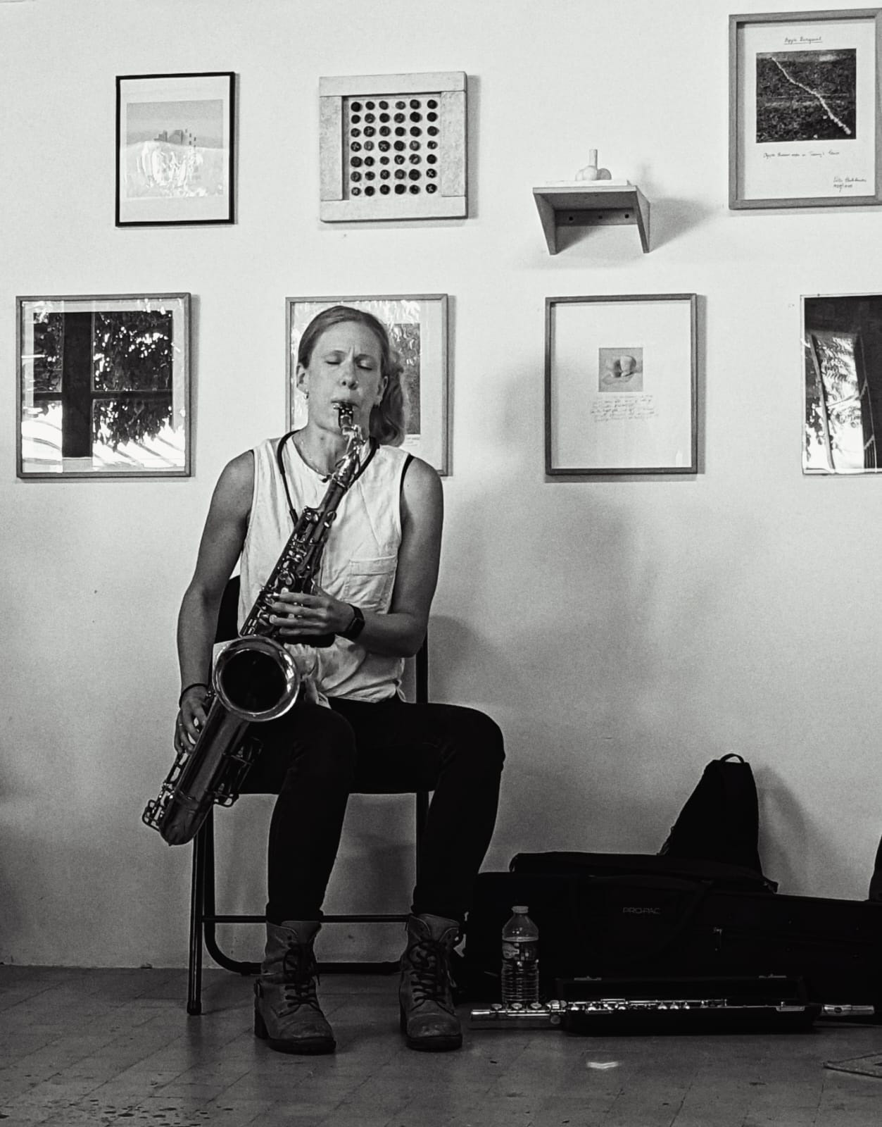 Greyscale portrait of Molly Jones seated, playing saxophone