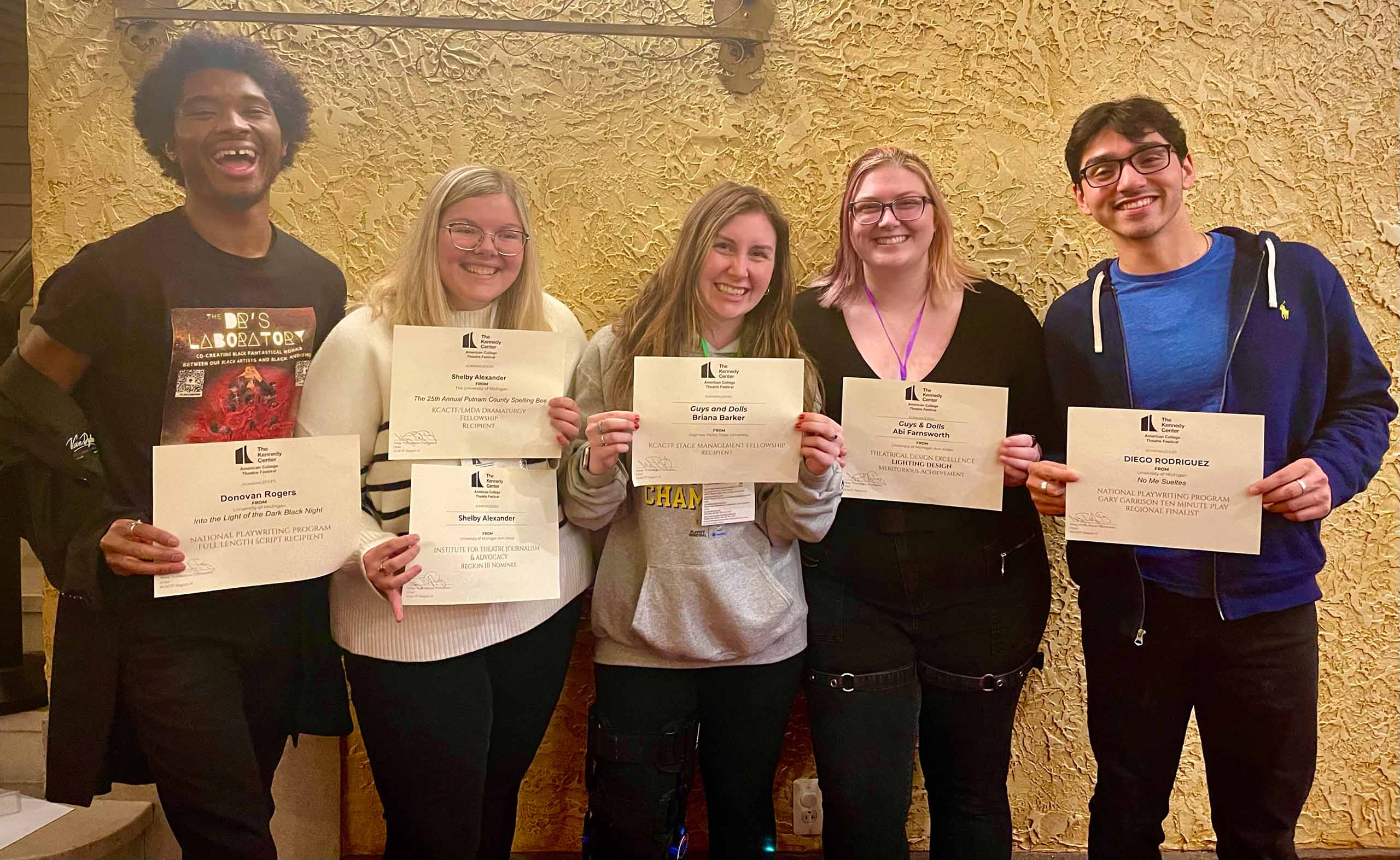 Five students pose standing, holding up their KCACTF competition certificates