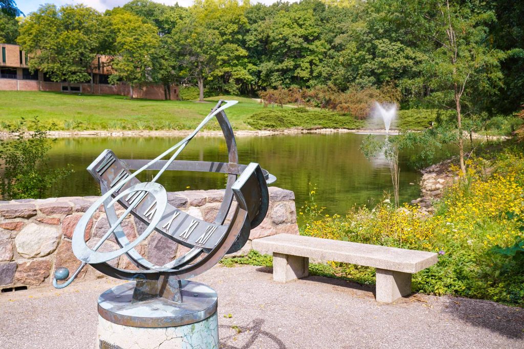 Treble Clef sculpture and pond with fountain; Moore Building in background
