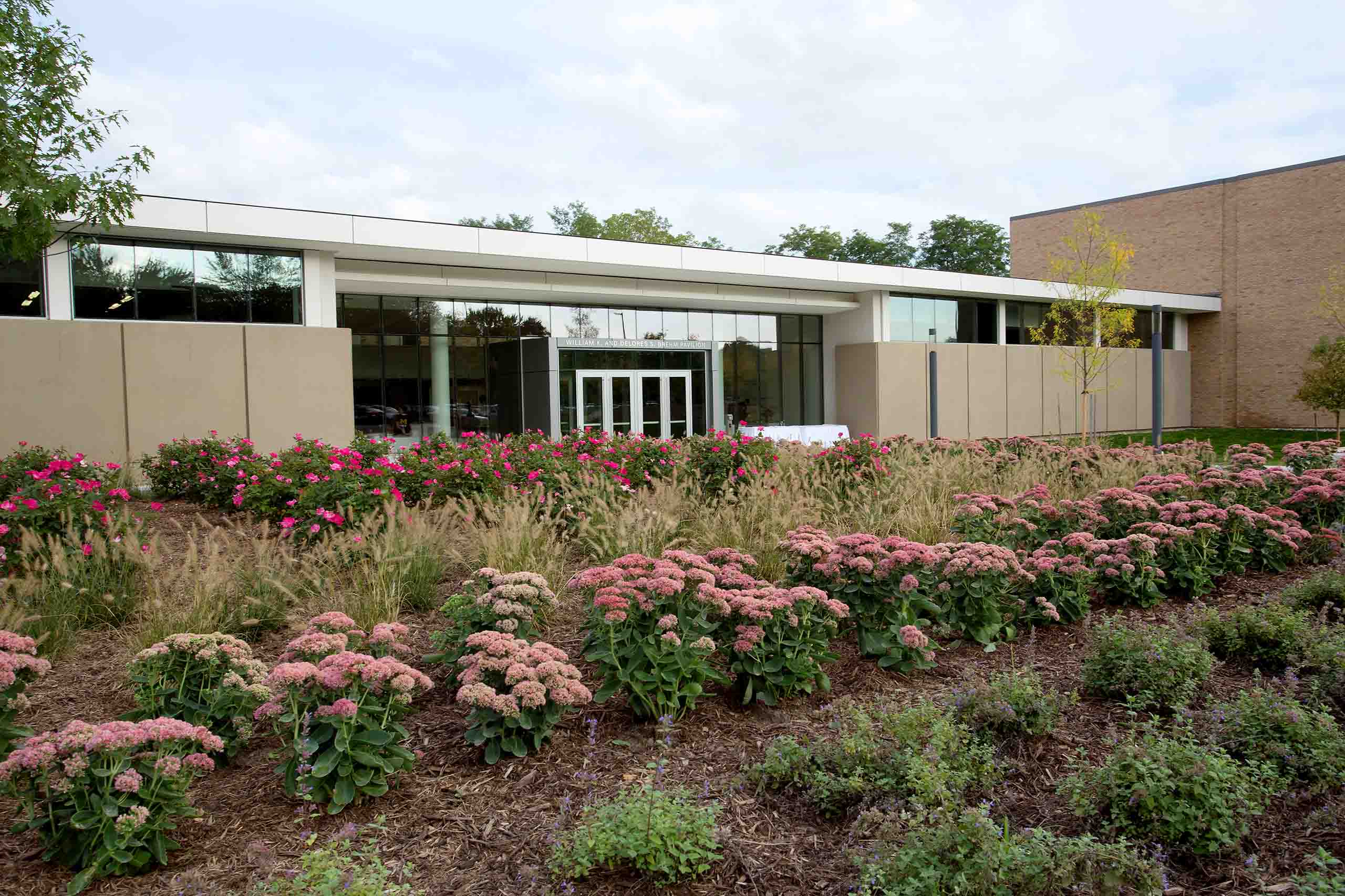 Flower beds outside the brick Moore Building; with the large glass entry doors to the Brehm Pavilion.