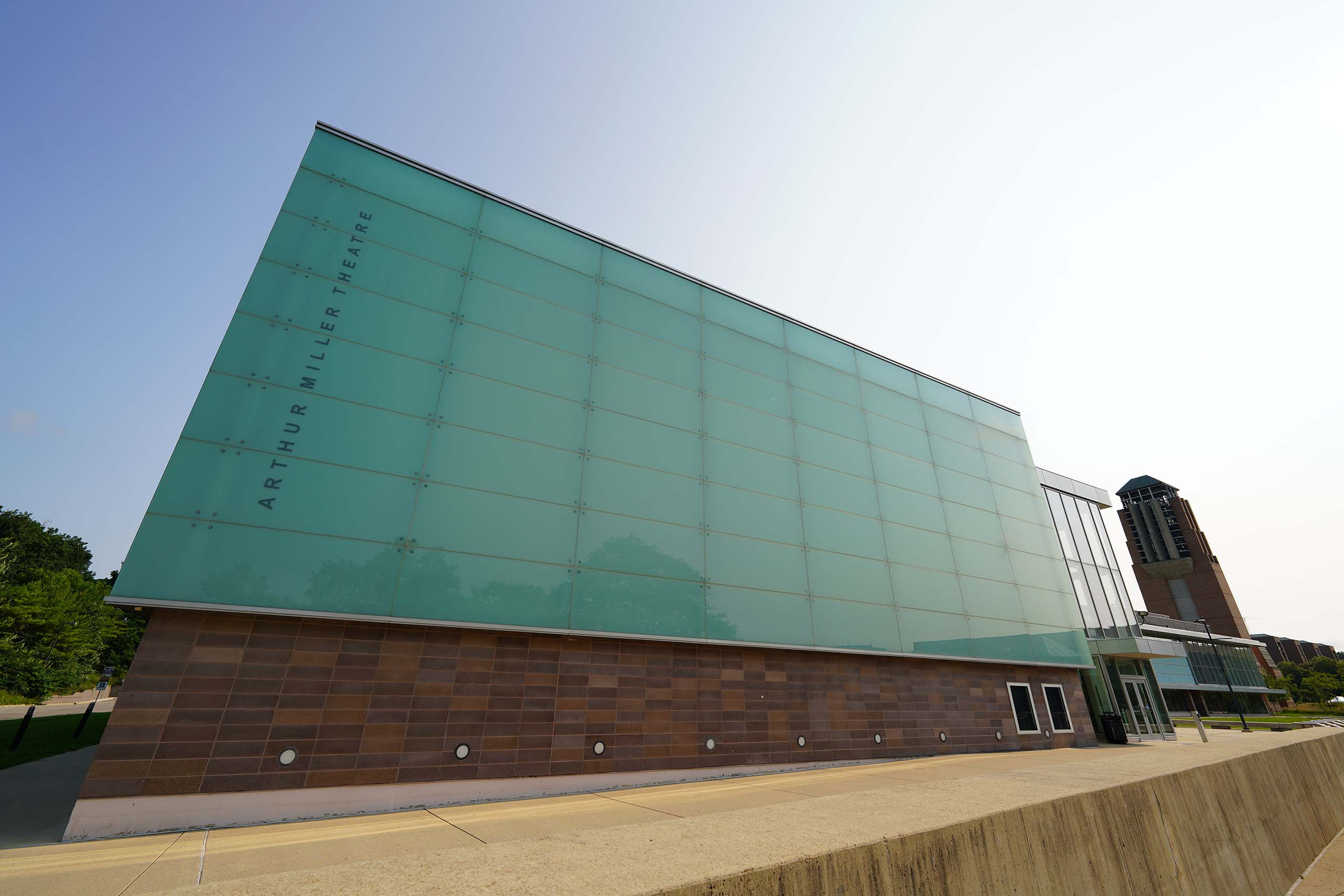 The multi-story exterior of Walgreen Drama Center glad in green-tinted glass; Lurie Tower in the far right distance.