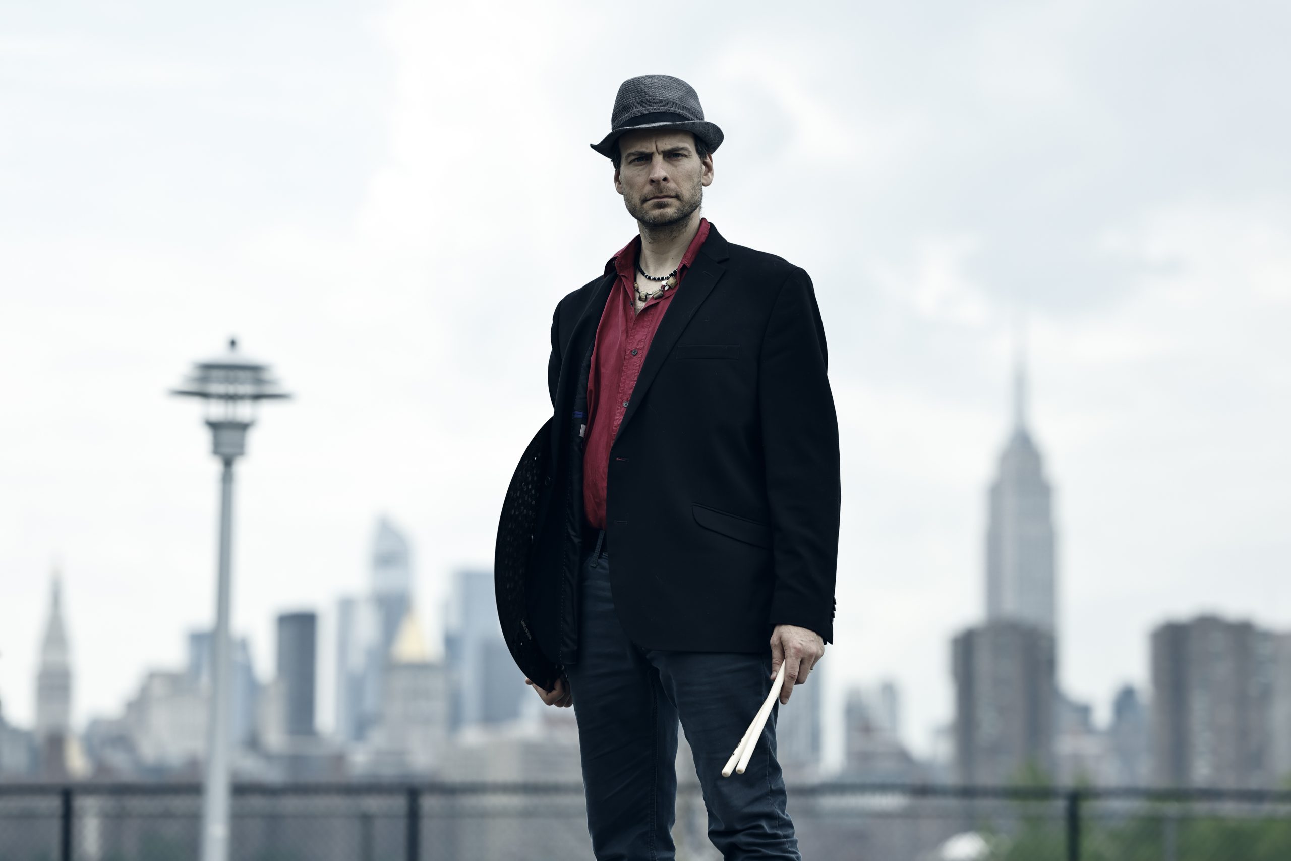 Percussionist Ari Hoenig standing in front of a city scape