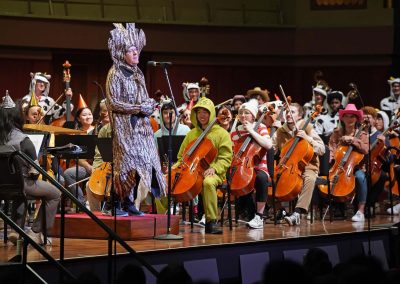 Kenneth Kiesler speaks to the crowd in costume from the conductor's podium