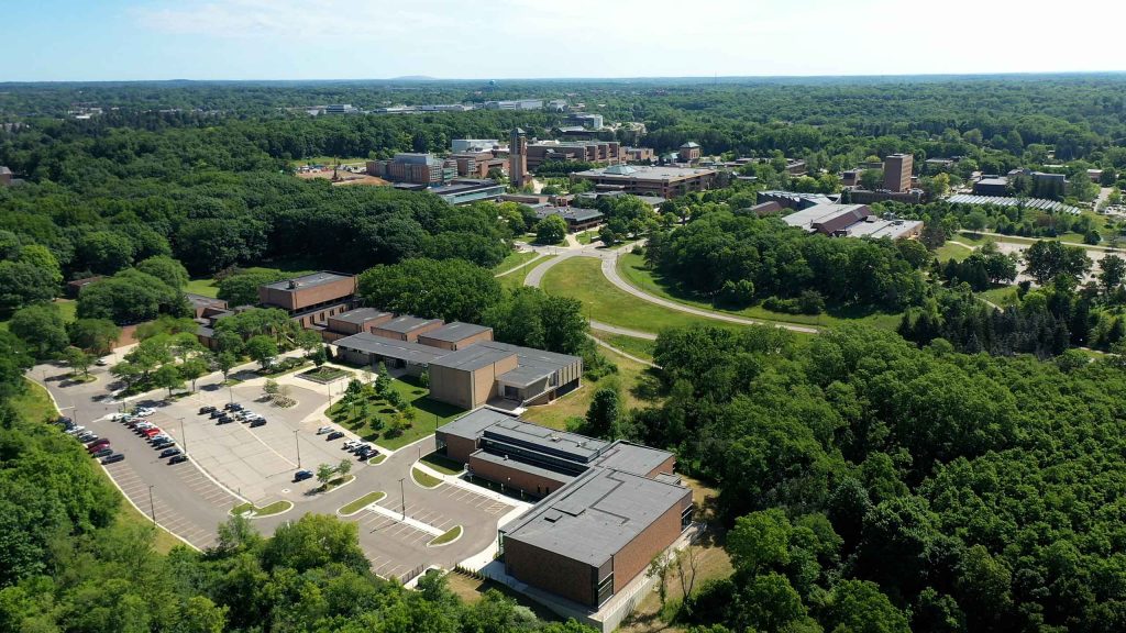 Aerial photograph of North Campus with Moore/ Dance buildings in the foreground and other buildings beyond; the trees are full of leaves