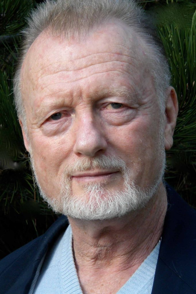 Portrait of Erik Fredricksen cropped closely to the face; wearing a grey sweater and dark jacket