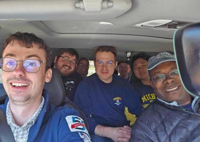 Six students and Professor David Jackson ride together in a van during the Symphony Band Tour.
