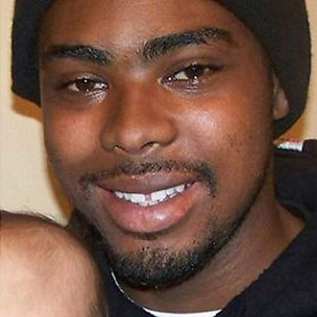 Casual portrait of Oscar Grant, wearing a black shirt and hat.