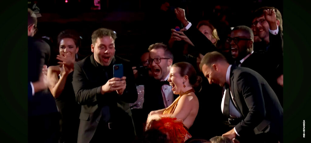 Photographed from the crowd at the Grammys, the members of Akropolis Quintet react to their win with excited faces and celebration.