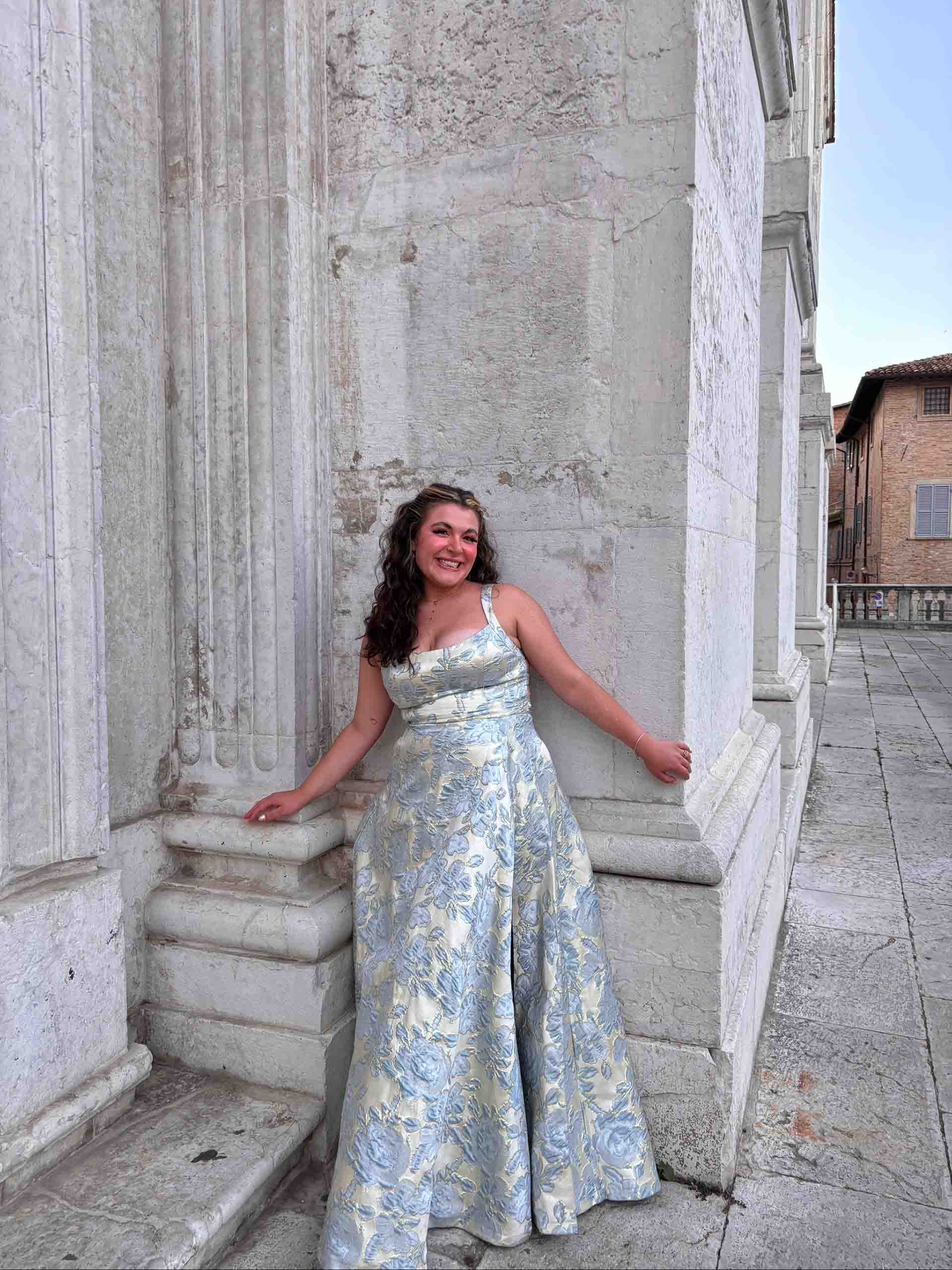 Grace Ryan Grace Ryan poses standing next to a historic marble building, attired in a concert gown.