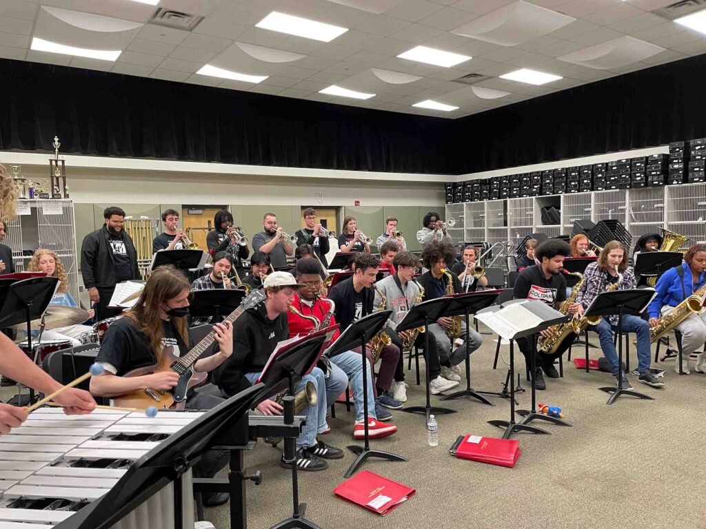 The Jazz Ensemble performs in casual attire in a band classroom.