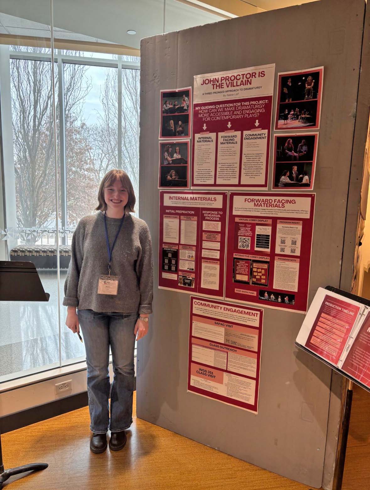 Reese Leif dramaturgy at KCACTF Photo Leo Kupferberg Reese Leif poses standing next to a conference display full of information and photos.