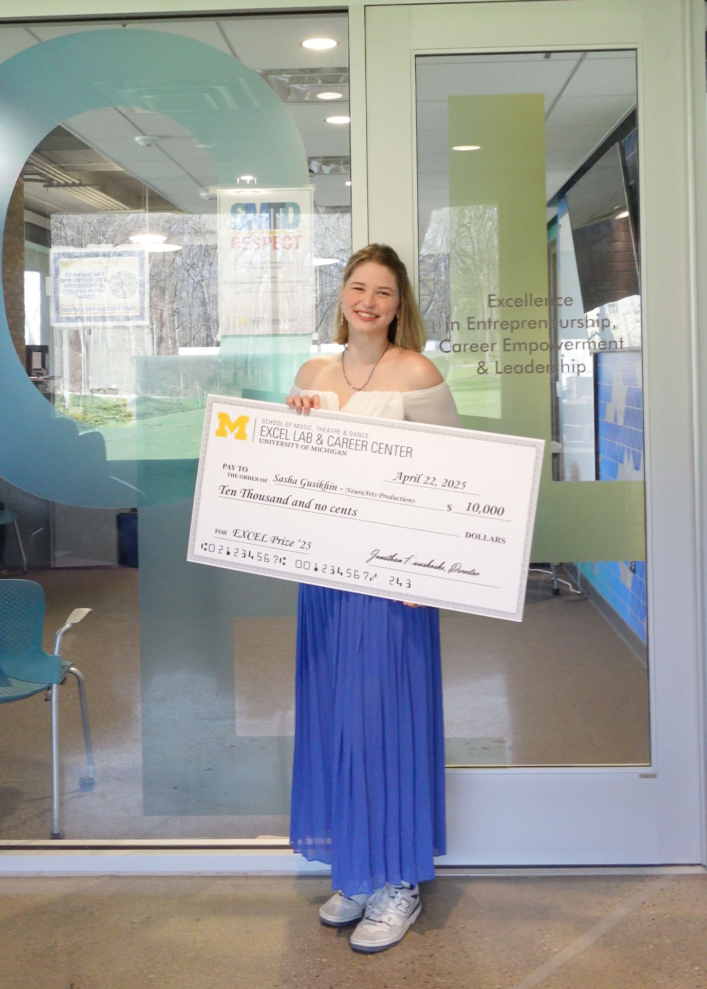 Sasha Gusikhin 2025 EXCEL Prize Sasha Gusikhin poses standing outside the EXCEL Lab, holding a giant check for the $10,000 EXCEL Prize.