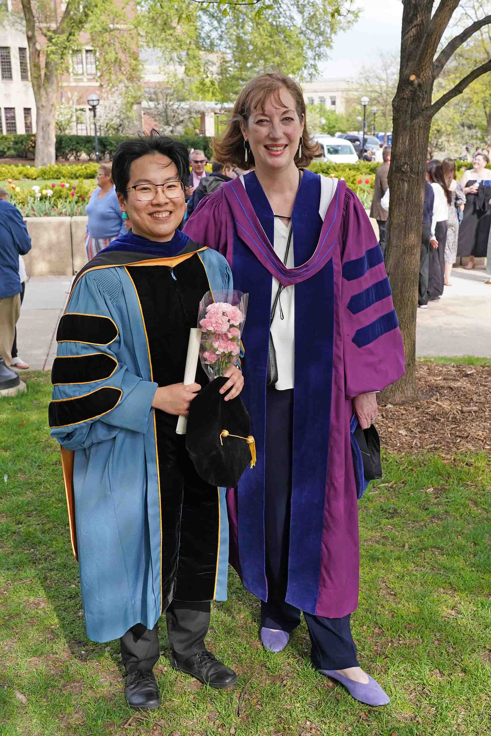 Sylvie Tran dissertation advisor Karen Fournier regalia 2025 Sylvie Tran and Karen Fournier pose standing outdoors on Central Campus, attired in doctoral regalia for commencement.