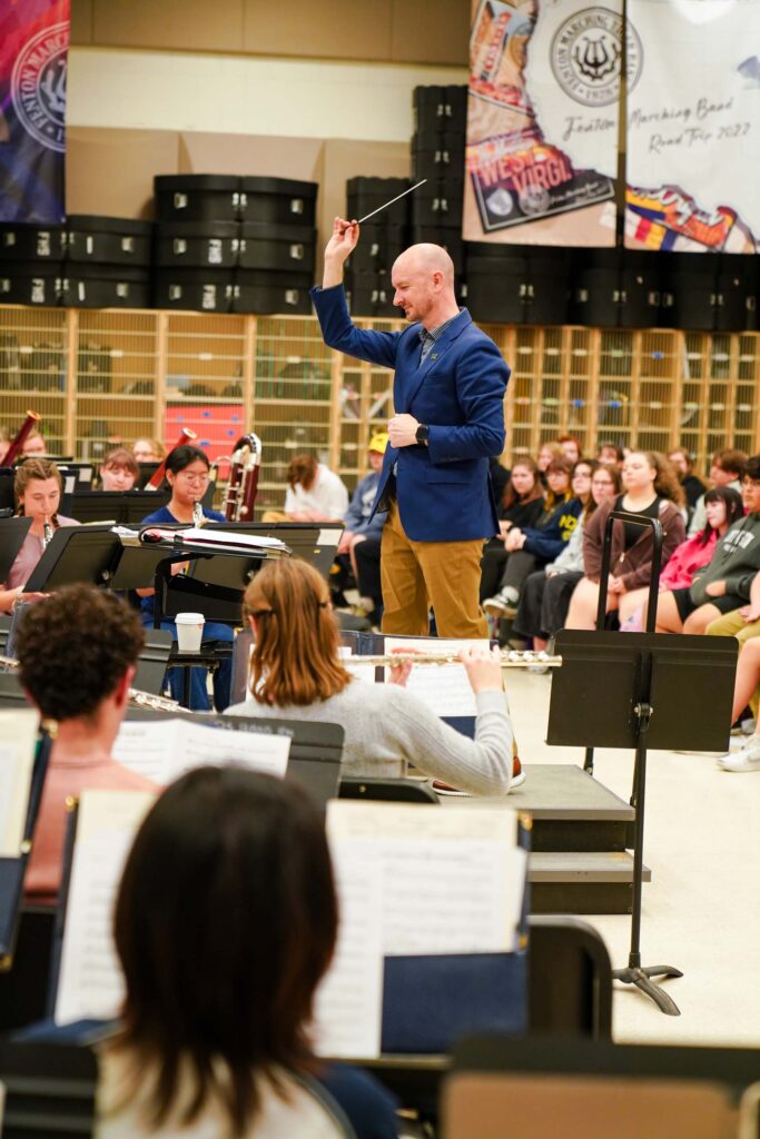 Jason Fettig conducts the Symphony Band as they perform in a band classroom.