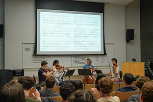 MPulse Composition students watch a string quartet play and follow along with the score