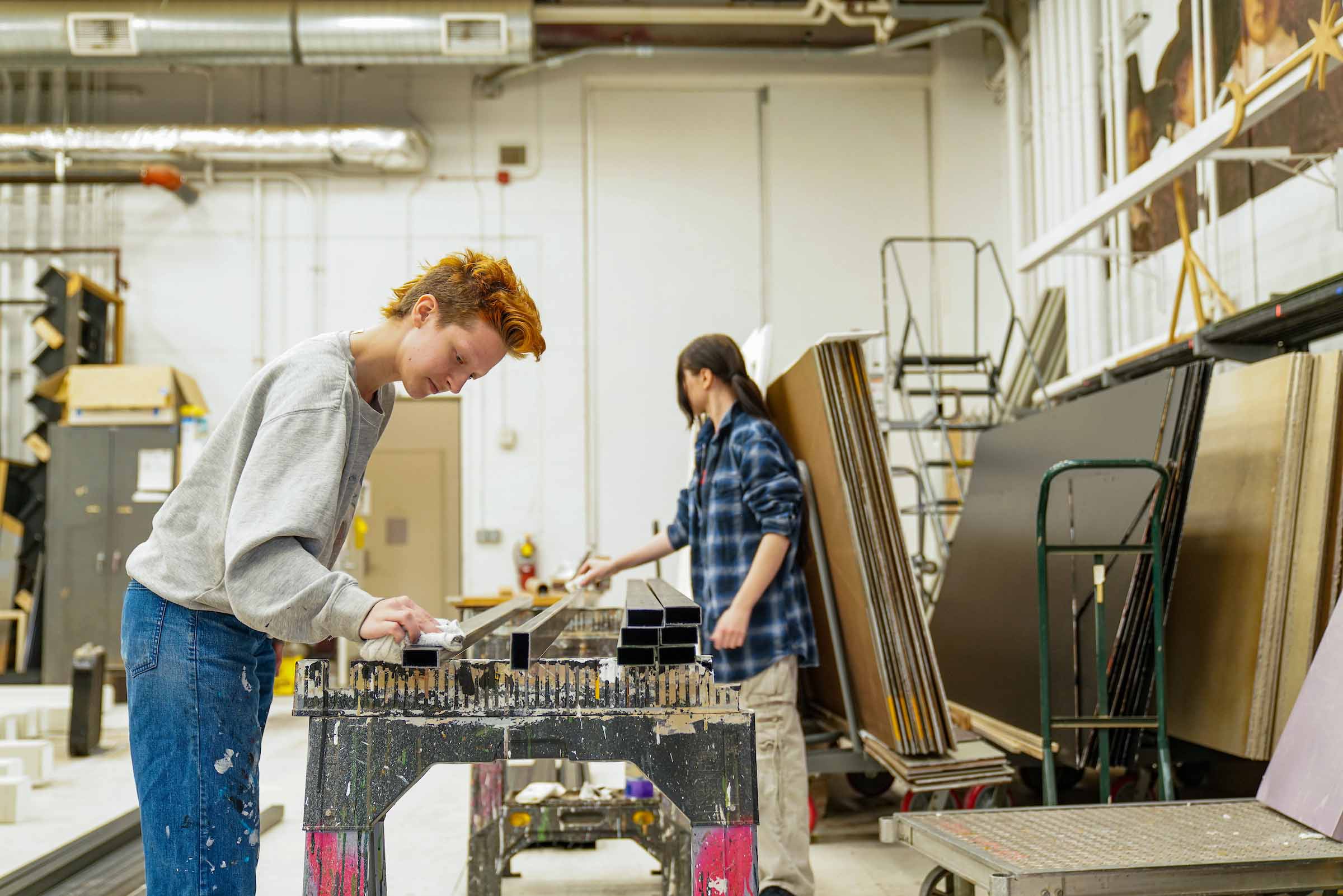 6 Students Russell and Kryzhan Walgreen Scene Shop In the scene shop, two students work on long pieces of scenery structure propped up on sawhorses.