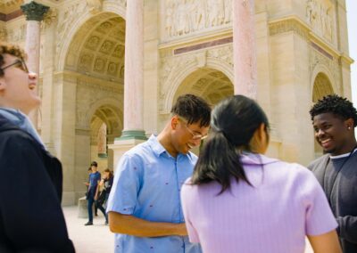 A group of four students laughing and looking up at the architecture around them