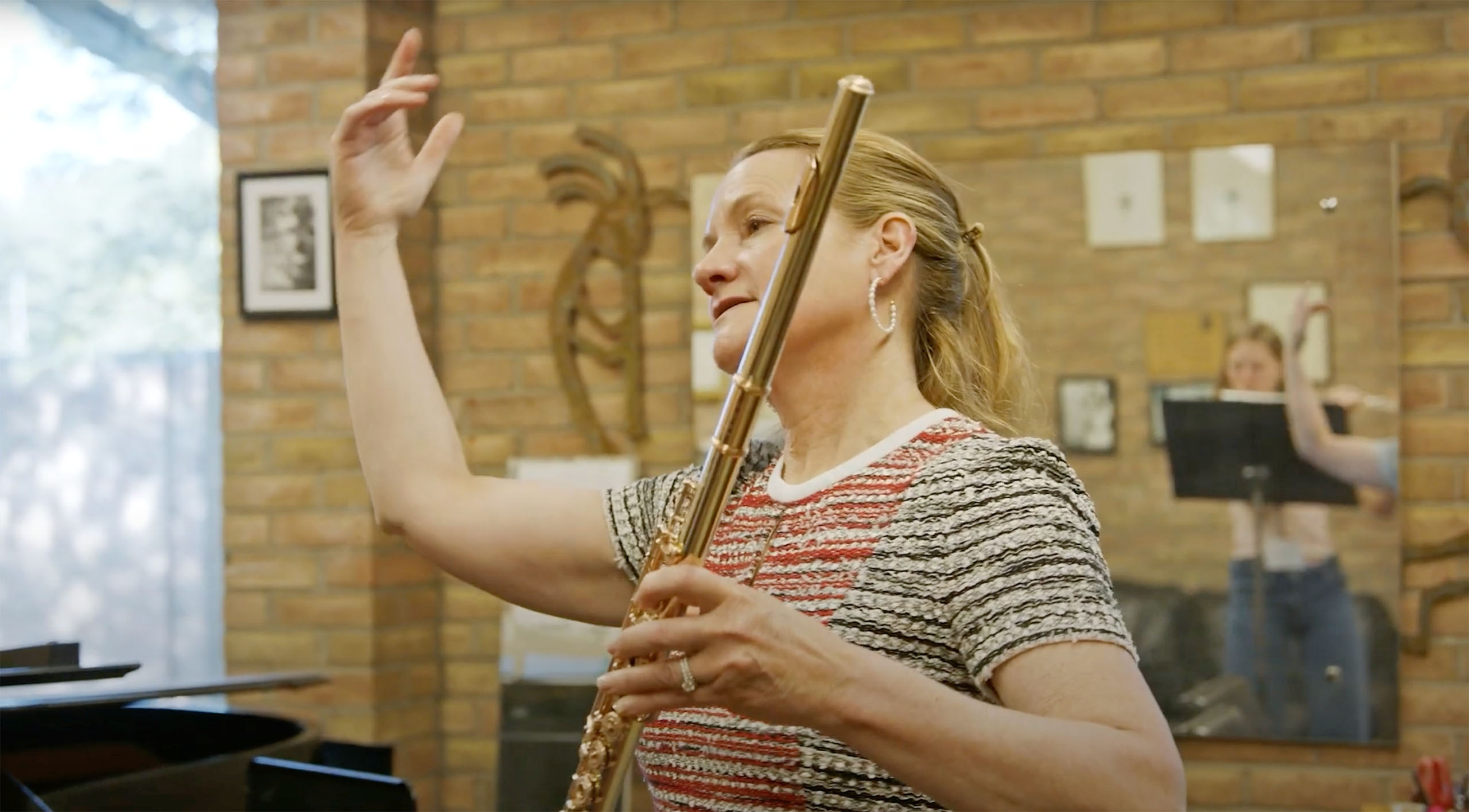 Candid photo of Amy Porter teaching a lesson while holding her flute.