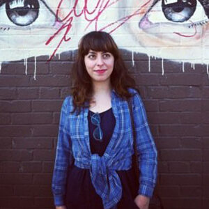 Portrait of Shirin Barghi taken next to a wall mural.