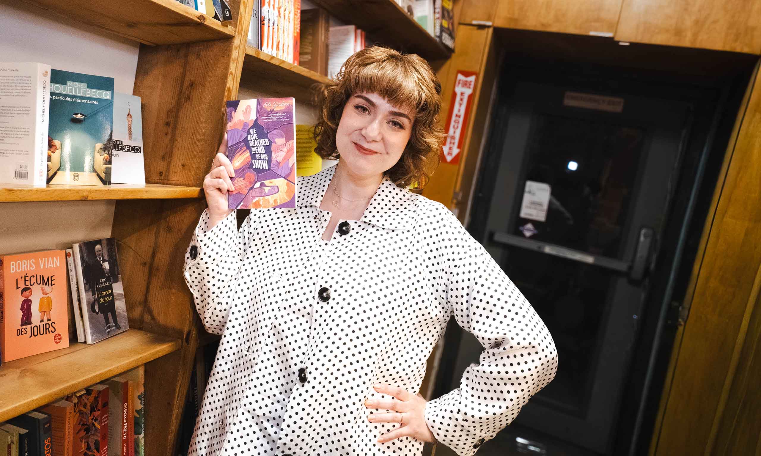 Ali Gordon poses at a bookstore, holding up her book.