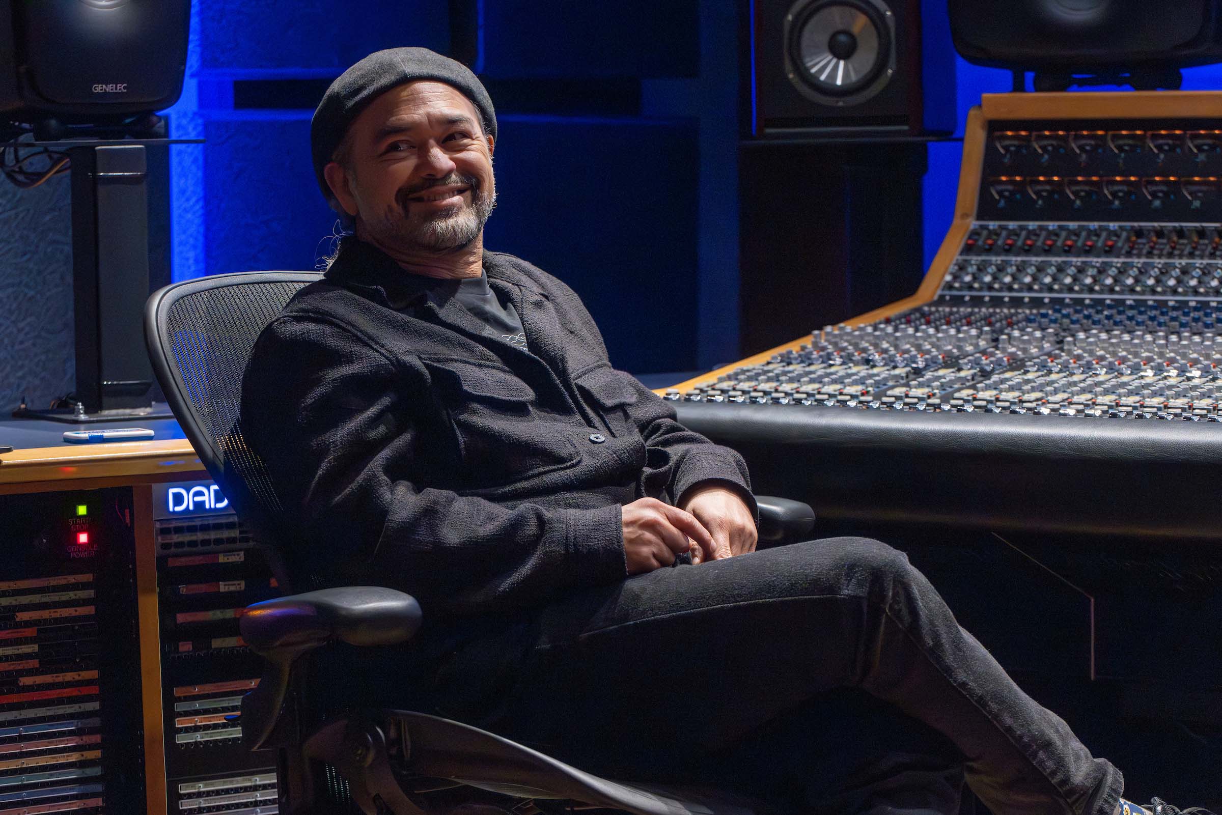 Candid photo of Erik Santos seated at a music mixing station in a studio space.
