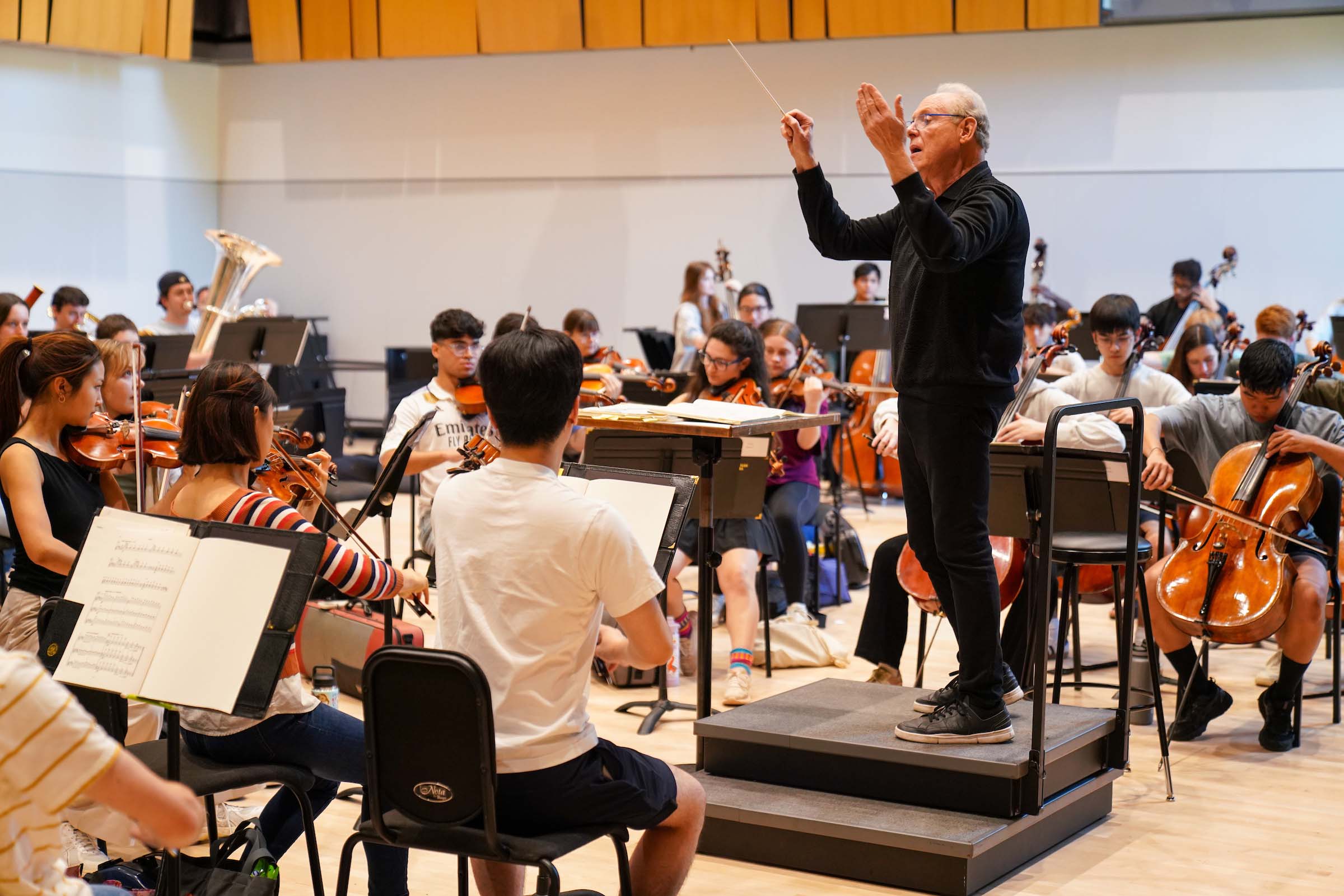 Kenneth Kiesler conducts an orchestra rehearsal.