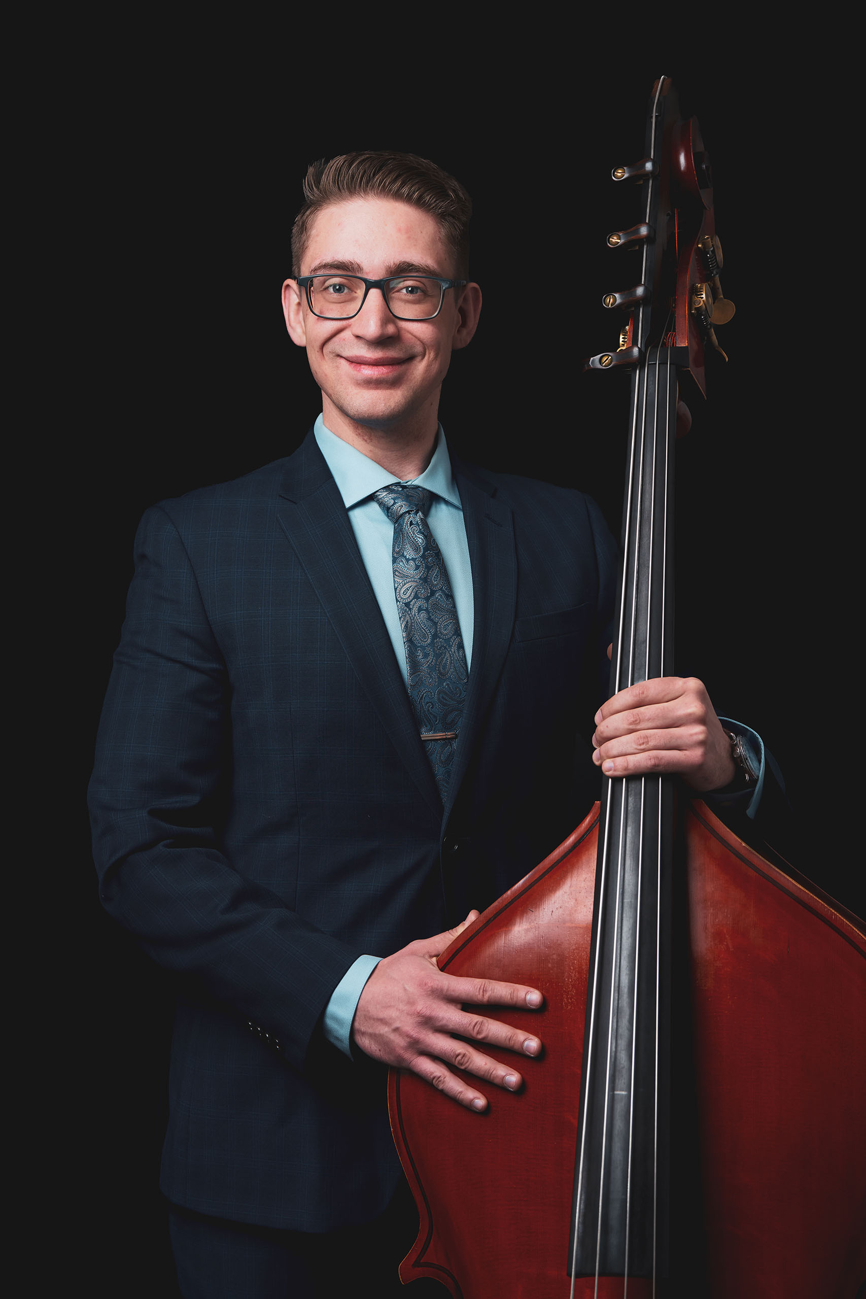 Studio portrait of Kurt Melendy standing with his double bass.