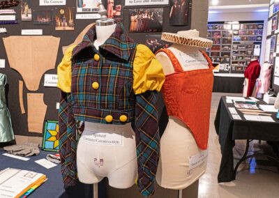 Two mannequins displaying a jacket and a corset made by Pfiel for Costume Construction and Period Costume Construction.