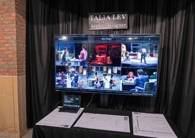 Talia Lev’s display featuring set blueprints and a digital display of production photos.