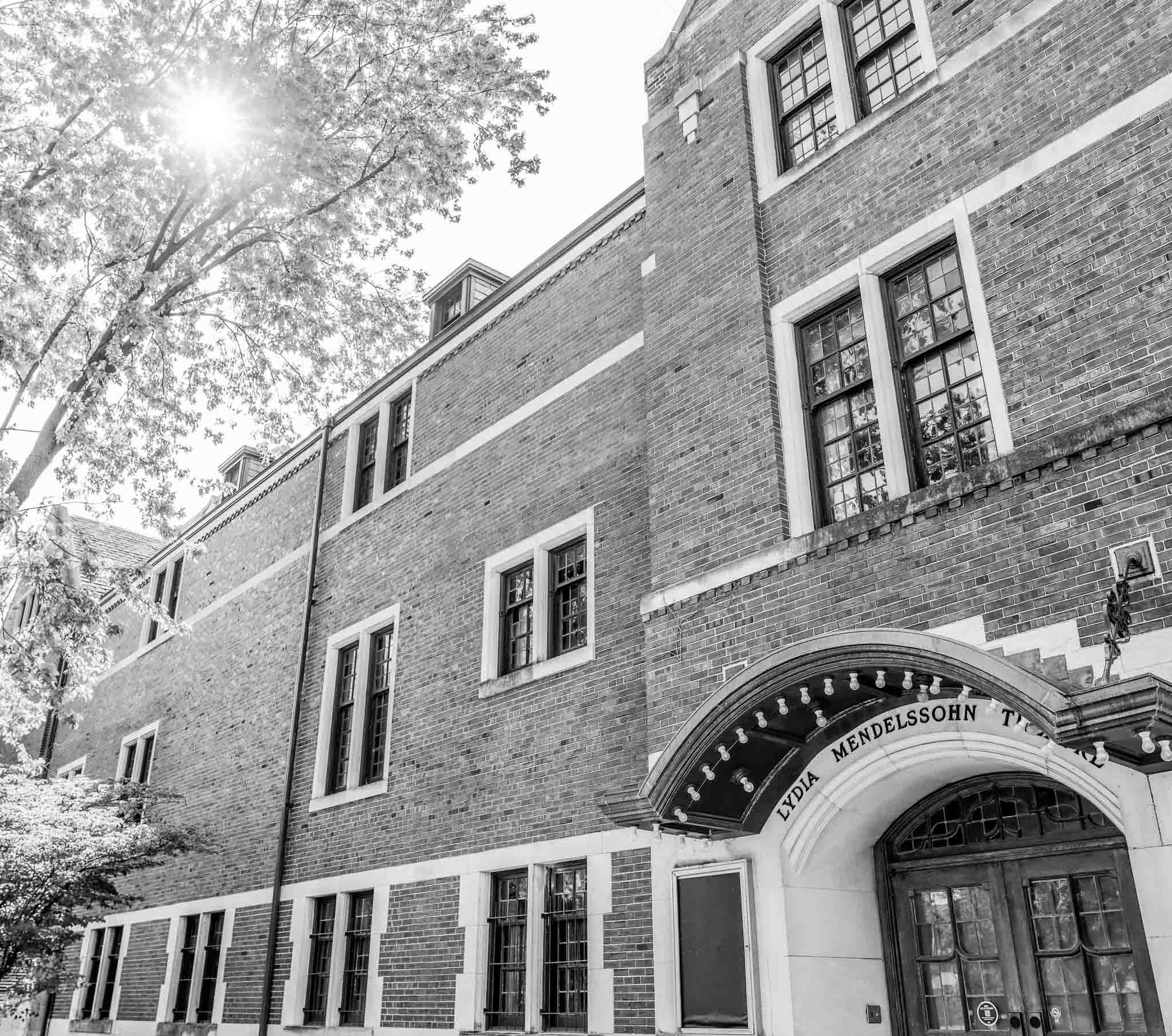 Exterior of the historic, brick Mendelssohn Theatre with a tree rising above.